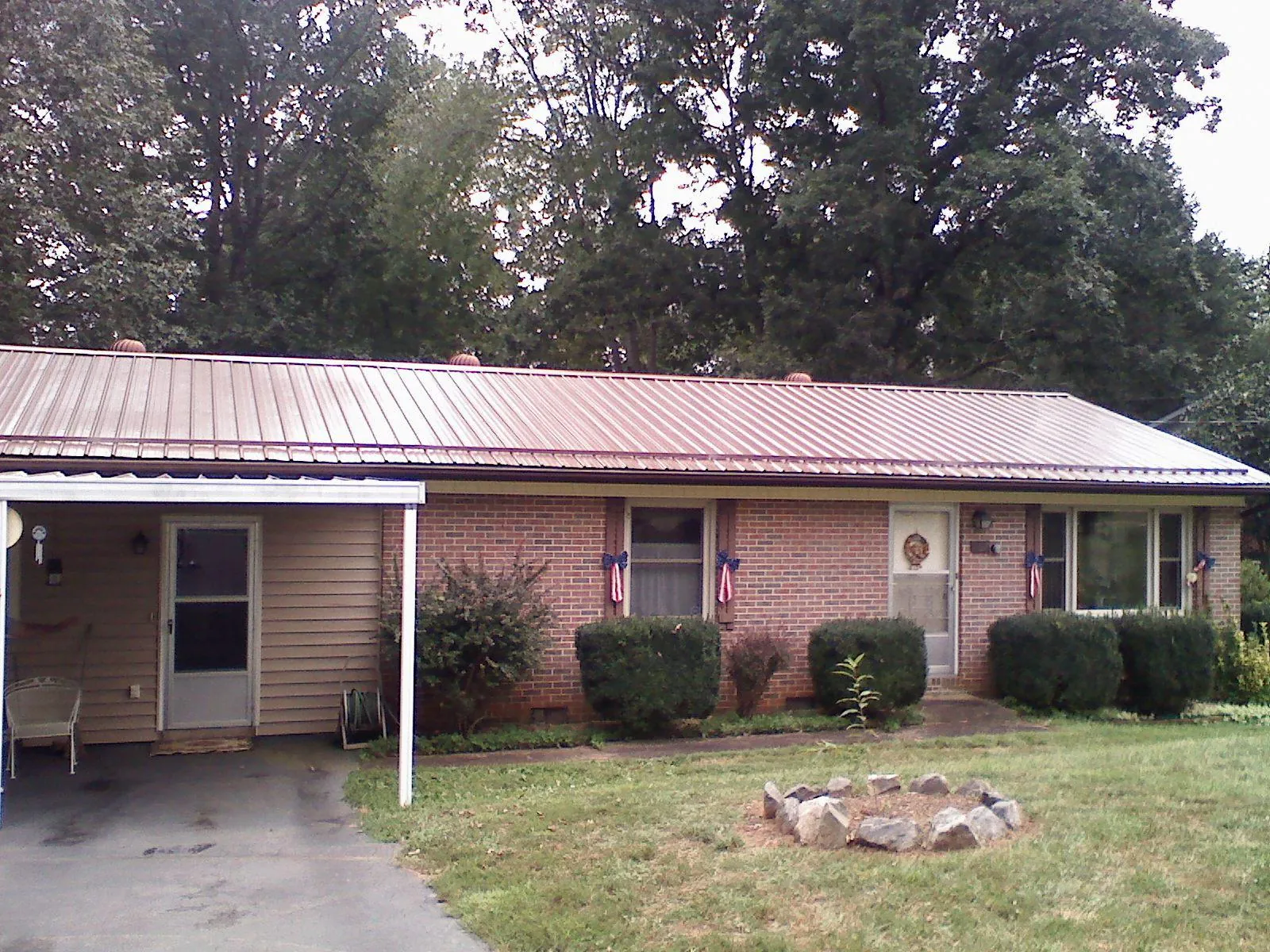 Bronze metal roof and carport on a brick ranch home — Roof Repair work by our crew in Lonedell