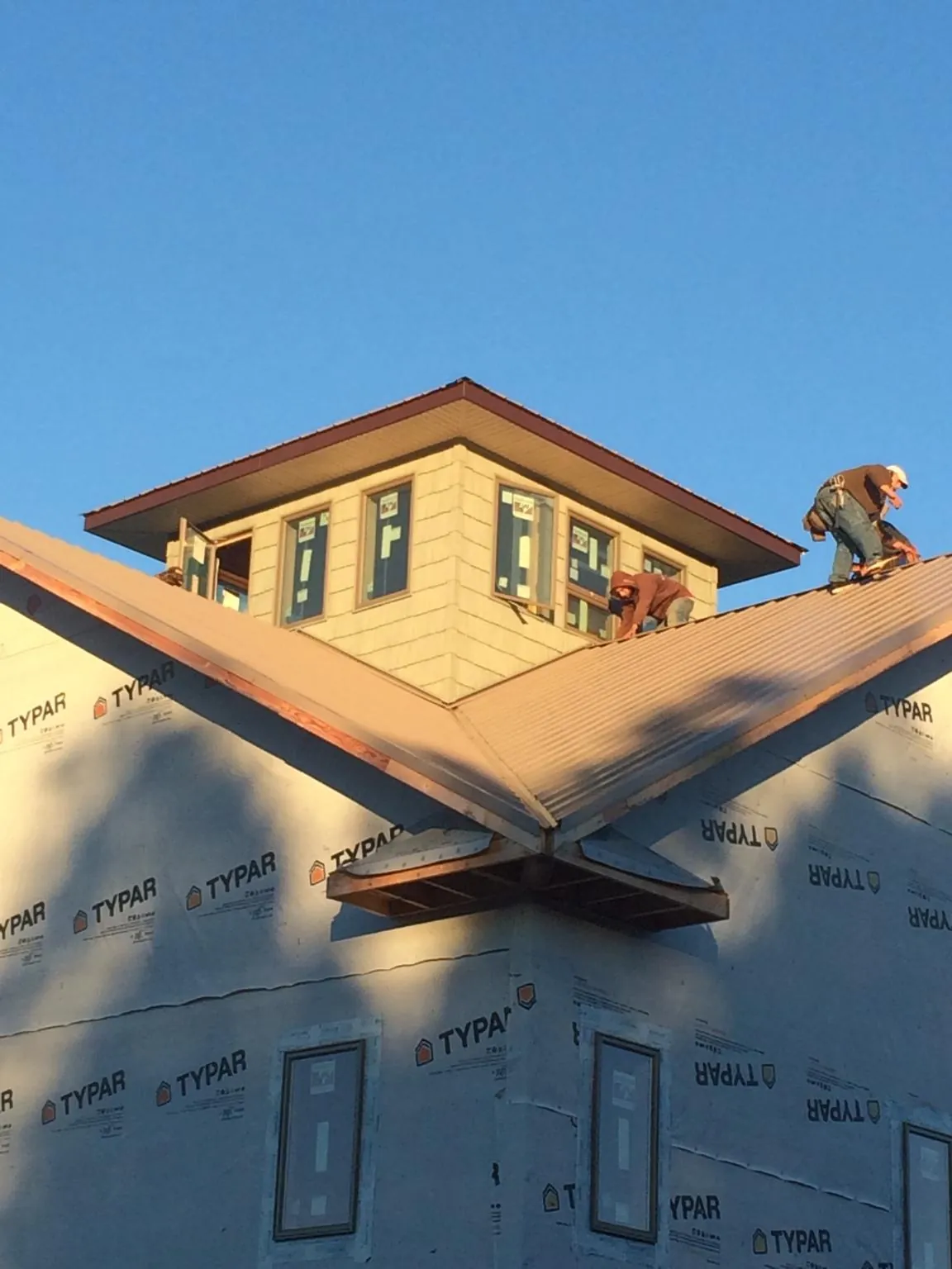 Roofers working around a rooftop cupola on a new metal roof at sunset — Roof Waterproofing in Lonedell by Roofing Brothers